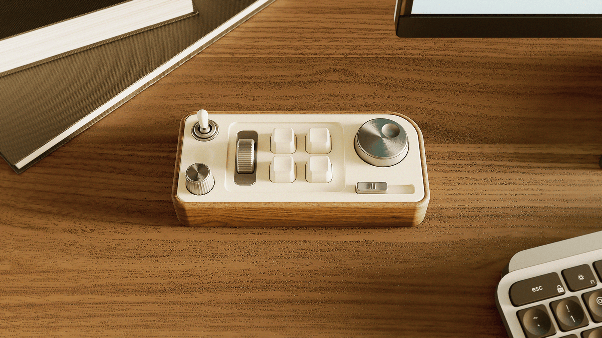 A 3D render showing Focus Deck, the analogue desk fidget with walnut body, cream faceplate and metal controls beside a keyboard.